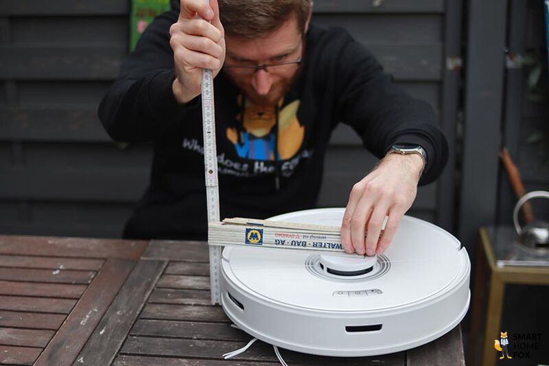 Der Roborock Q7 Max Staubsauger-Roboter wird mit einem Lineal ausgemessen